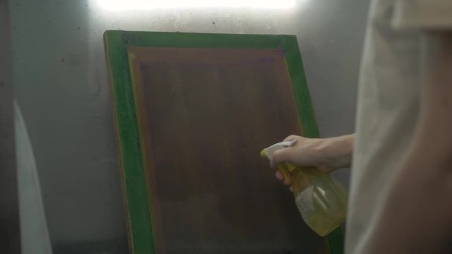Textile factory equipment - stencils with patterns for printing on cloths and paints, man prepare silkscreen print