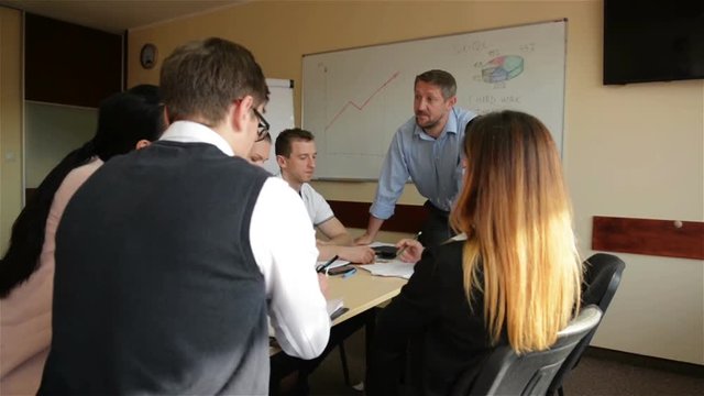 Angry Boss Scolding Female Employee For Bad Work Result Sitting at Conference Table. Male Director Yelling at Incompetent Subordinate Blaming For Mistake In Financial Document At Diverse Team Meeting.