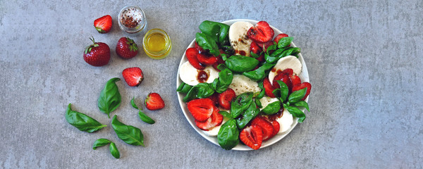 Fototapeta na wymiar Summer caprese salad. Caprese with strawberries. Dietary salad with basil and mozzarella. Keto diet.
