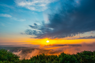 Sunrise on a foggy summer morning over the village