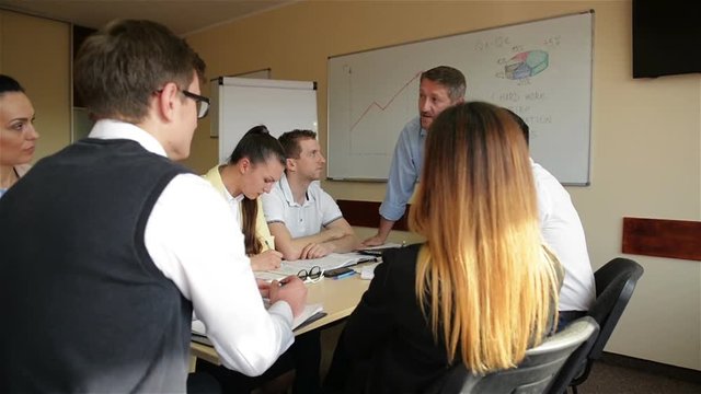 Angry Boss Scolding Female Employee For Bad Work Result Sitting at Conference Table. Male Director Yelling at Incompetent Subordinate Blaming For Mistake In Financial Document At Diverse Team Meeting.