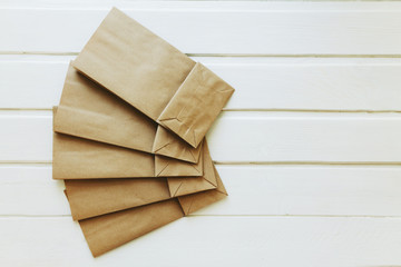Paper bags on light wooden floor. Simple brown paper bags for lunch or meal. The layout for the...
