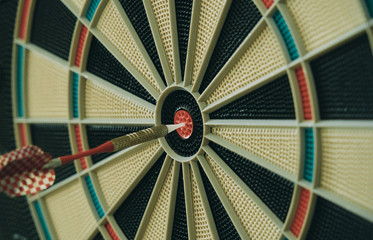 Closeup of dart board with dart in the bulls eyes.