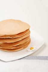 Homemade breakfast. American style pancakes served on white table and towel. Copy spase.  Selective focus
