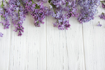 Frame for a banner of lilac flowers on a white wooden background. Background with spring flowers....