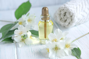 Obraz na płótnie Canvas Photo for a spa center with a jar of jasmine oil and jasmine flowers. Aromatherapy and oil for massage. Cosmetic oil jasimna