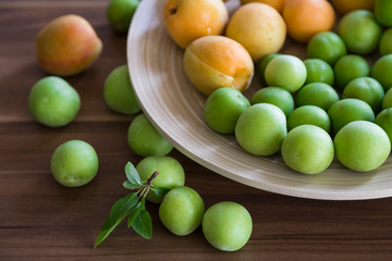 plum and apricot fruits in the wooden plate for food photography concept or healthy life.