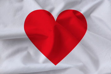 red heart on white silk, symbol of love and donation