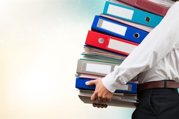 Young businessman with stack of papers
