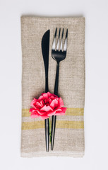 Fork, knife and linen napkin on white background.