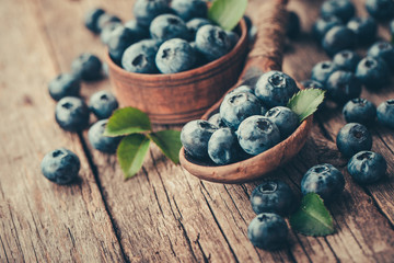 Fototapeta na wymiar Blueberries in wooden spoon on old wood background. Healthy eating and nutrition concept.