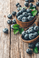 Blueberries in wooden spoon on old wood background. Healthy eating and nutrition concept.
