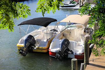 Fototapeta na wymiar Close up docked beautiful boats at wooden dock on canal in Florida, USA
