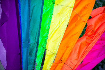 Rainbow flag parachute fabric fills the frame for a colorful background of gay pride, inclusiveness, and tolerance