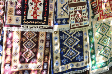 Hand-made carpets hanging in street market.