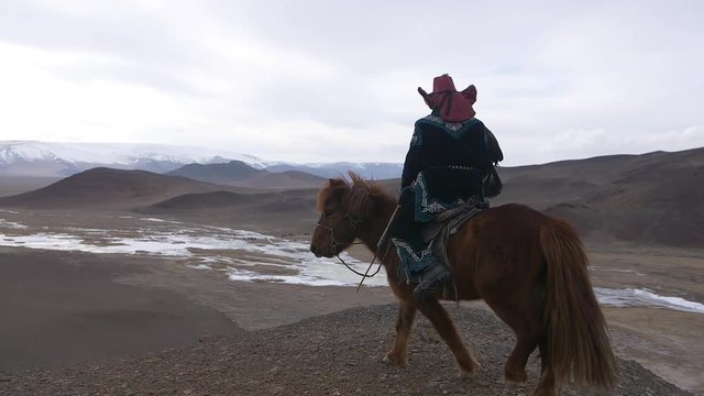 Mongolia eagle hunter on a horse in the mountains
