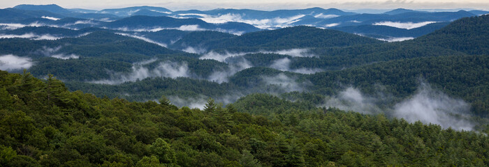 Mountain panoramic with the ridges and clouds betweeen them in summertime