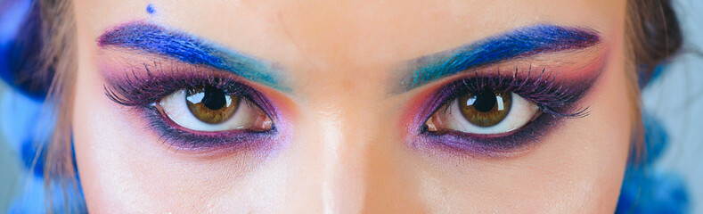 Beautiful macro shot of female eye with colorful makeup. Perfect shape of eyebrows, rainbow...