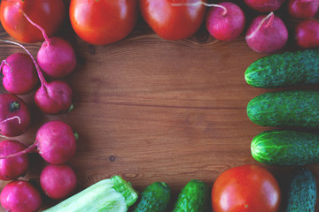 Vegetable frame for dough from cucumbers, radish, tomatoes, on wooden background top view, lifestyle
