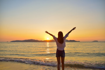 Fototapeta na wymiar Women Standing on Beach at Sea And Sunset Background Summer Holidays