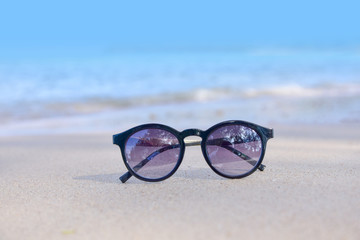 Fototapeta na wymiar Sun Glasses on Beach at Sea And Sunset Background Summer Holidays