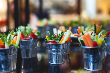 Beautifully decorated catering banquet table with variety of vegetables and different vegan vegetarian snacks on corporate christmas birthday party event or wedding celebration