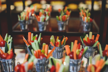 Beautifully decorated catering banquet table with variety of vegetables and different vegan vegetarian snacks on corporate christmas birthday party event or wedding celebration