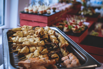 Beautifully decorated catering banquet table with assortment variety of different food snacks and appetizers on corporate christmas birthday party event or wedding celebration