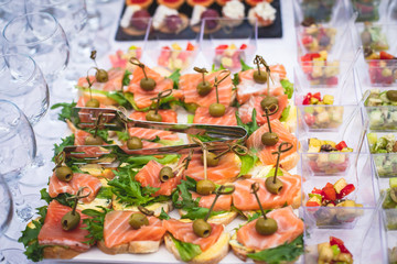 Naklejka na ściany i meble Beautifully decorated catering banquet table with assortment variety of different food snacks and appetizers on corporate christmas birthday party event or wedding celebration