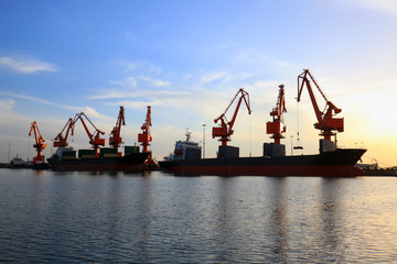 Gantry crane and cargo ship in the evening