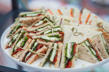 Beautifully decorated catering banquet table with different food snacks and appetizers with sandwich, on corporate christmas birthday kids party event or wedding celebration