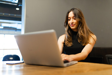 Business woman work process concept. Young woman working university project with generic design laptop. Blurred background, film effect.