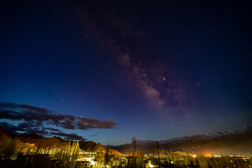 Obraz na płótnie Canvas Panorama of arching Milky Way galactic center over the mountain at Leh city, Ladakh, Jammu and Kashmir, India.