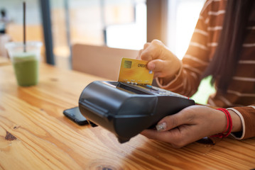 Young asian woman paying her order by credit card.
