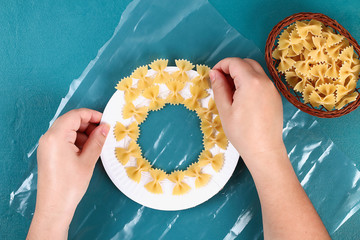 Diy Christmas pasta wreath on blue background. Gift idea, decor Christmas, Xmas, New Year