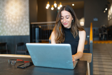Business woman work process concept. Young woman working university project with generic design laptop. Blurred background, film effect.