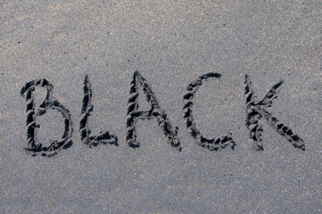 Black inscription drawn on black sand