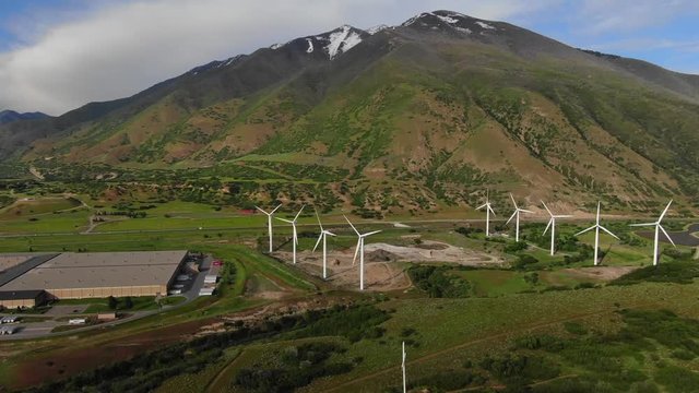 Windmill Farm wind park wind turbines Sunset Colors Farmland Field Wasatch Mountain Range Blue Skys Agriculture Farming Spanish Fork Canyon Utah Renewable Energy Cinematic Video USA 4K