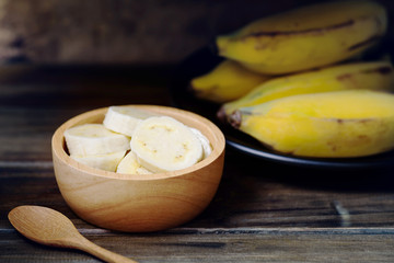 Sliced banana in a bowl on wooden table