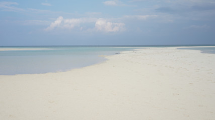 empty beach with white sand and blue clouds