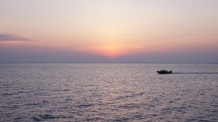 motorboat passes the sea at sunset