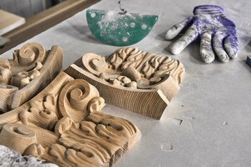 Preparation wooden carved chapiter for painting in painting chamber. Production of wood furniture....