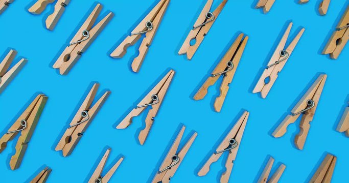 clothespins laid out in pattern alternating open and close stop motion on vibrant blue background