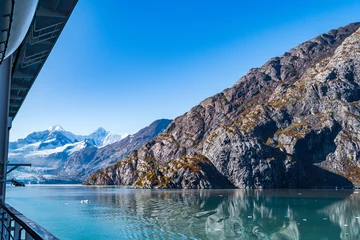 Papier peint photo Le salon Rocky mountain range in Glacier Bay Alaska with ice/snow covered, broken icebergs floating, reflection in water. Scenic nature tour sailing through the inlet basin in the National Park and Preserve.  © Debbie Ann Powell