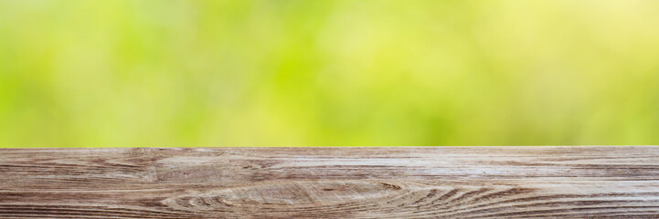 Wood table top on shiny bokeh green background. For product display.