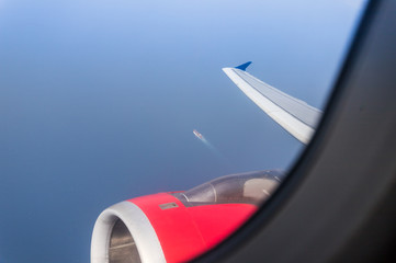 View  of the Mediterranean Sea, the wing of the aircraft and the engine of the aircraft from the illuminator of the flying airplane