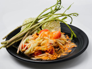 Papaya salad on black plate with white background.