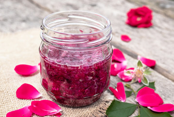 Fototapeta na wymiar Jam rose petals on a wooden table. Flower confiture. Healthy food.