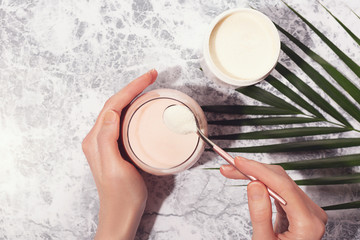 Woman hands, collagen powder and smoothie.