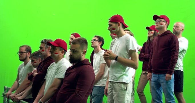 GREEN SCREEN CHROMA KEY 3/4 view group of people fans wearing red clothes watching a sport event. 4K UHD ProRes 422 HQ